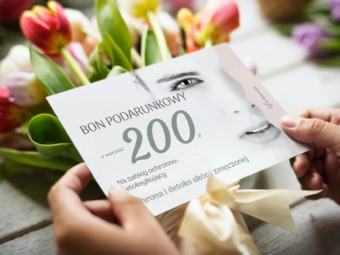 kartka trzymana w dloniach na tle kwiaty