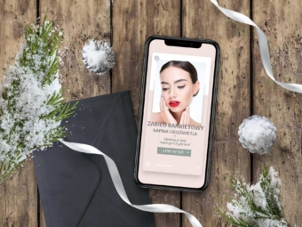 telefon na drewnianym stole w otoczeniu zielonej iglastej galazki