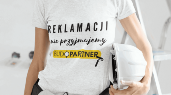 kobieta trzymajca w reku wiertarke i kask roboczy